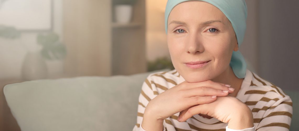 Young woman with cancer in headscarf indoors